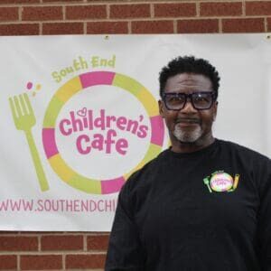 Man standing in front of Children's Cafe sign.