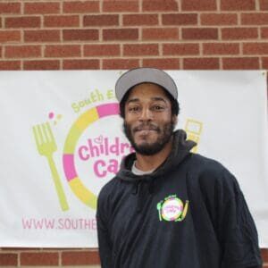 Man standing in front of colorful banner.